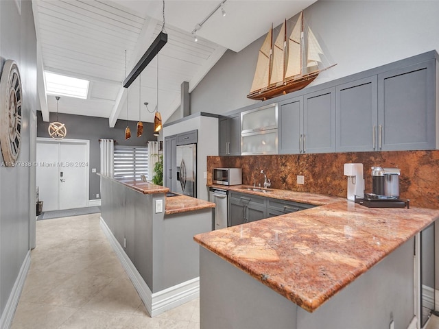 kitchen with decorative light fixtures, appliances with stainless steel finishes, backsplash, beam ceiling, and a center island