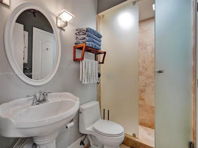 bathroom featuring tile flooring, tiled shower, and toilet