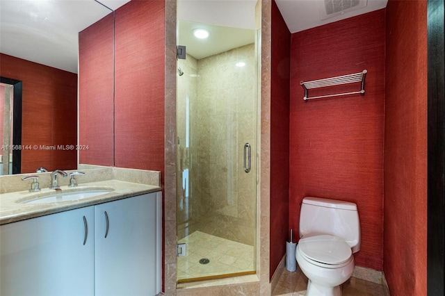 bathroom with tile flooring, an enclosed shower, vanity, and toilet