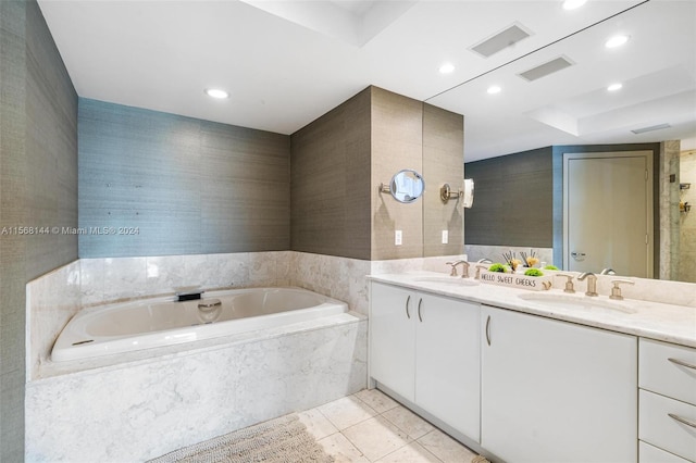 bathroom with oversized vanity, double sink, tile floors, and tiled tub