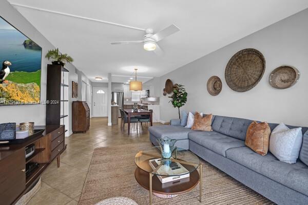 living room featuring tile patterned flooring and ceiling fan