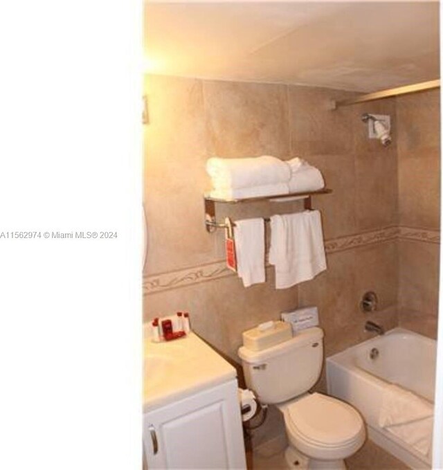 full bathroom with tiled shower / bath, vanity, and toilet