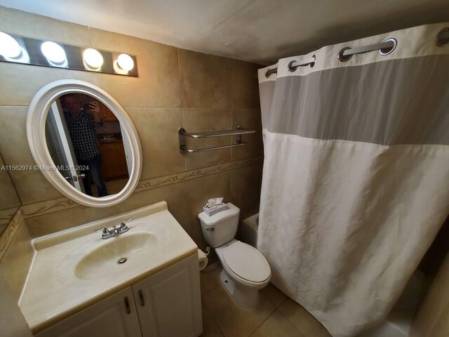 bathroom featuring tile patterned flooring, vanity, tile walls, and toilet