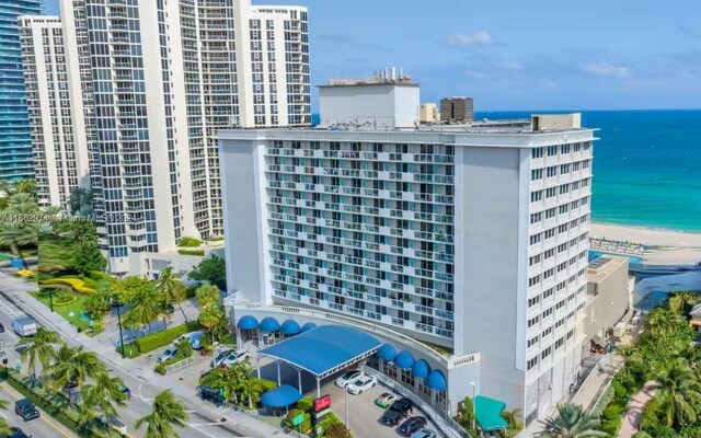 view of building exterior with a beach view and a water view