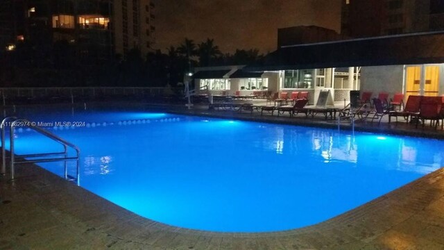 pool at twilight featuring a patio