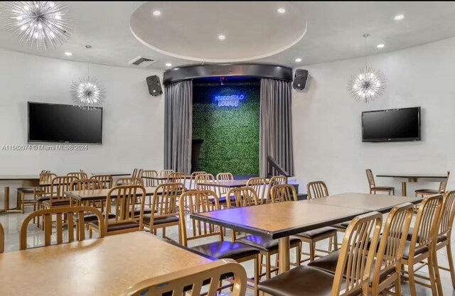 dining space with a raised ceiling and a notable chandelier