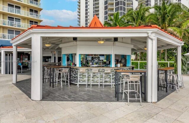 view of patio with a gazebo, ceiling fan, and exterior bar