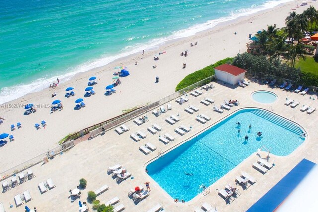 birds eye view of property featuring a water view and a beach view