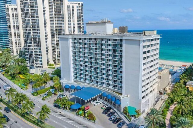 view of building exterior with a water view and a beach view