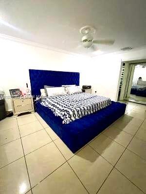 bedroom featuring tile flooring, ceiling fan, and crown molding