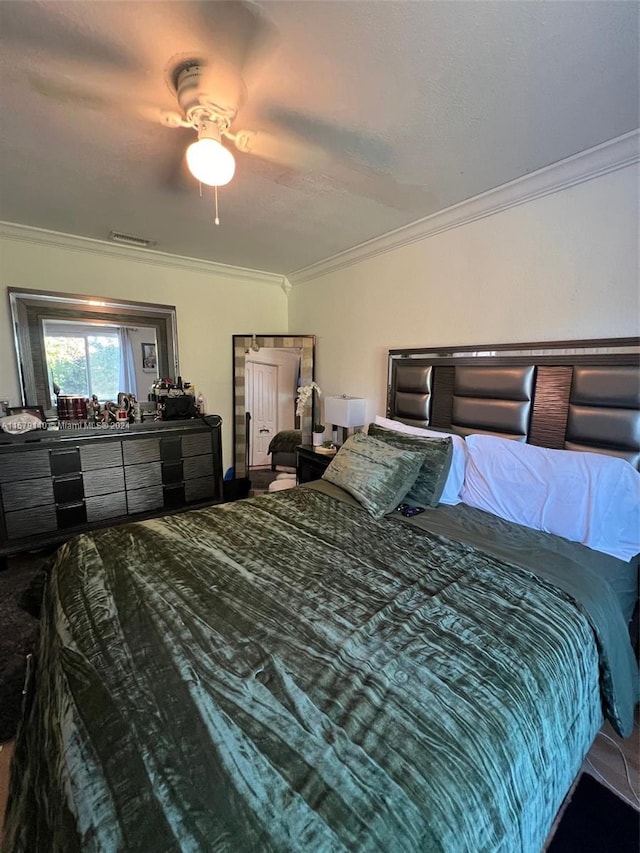 bedroom with ceiling fan and crown molding