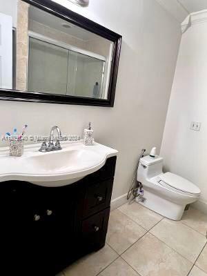 bathroom featuring large vanity, tile floors, and toilet