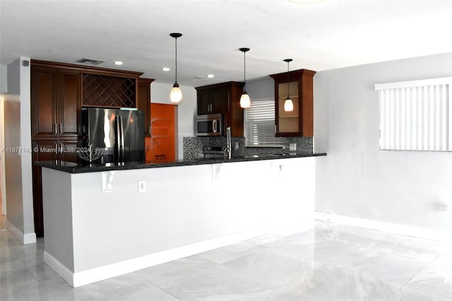 kitchen with backsplash, pendant lighting, light tile floors, and stainless steel appliances