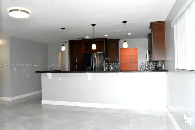 kitchen with decorative light fixtures, light tile floors, and stainless steel appliances