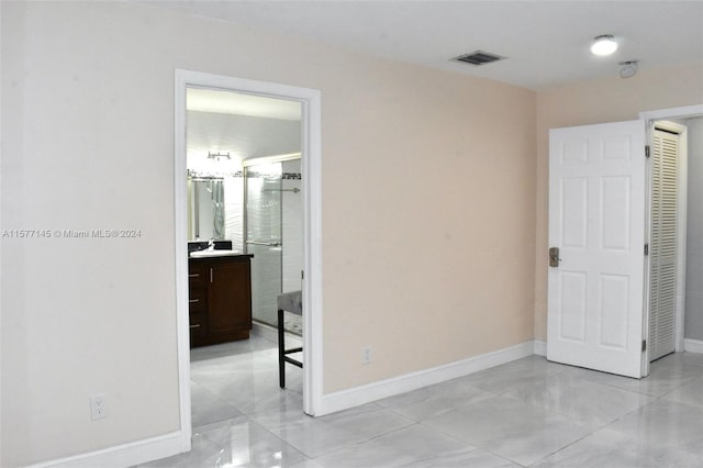 tiled bedroom featuring sink and connected bathroom