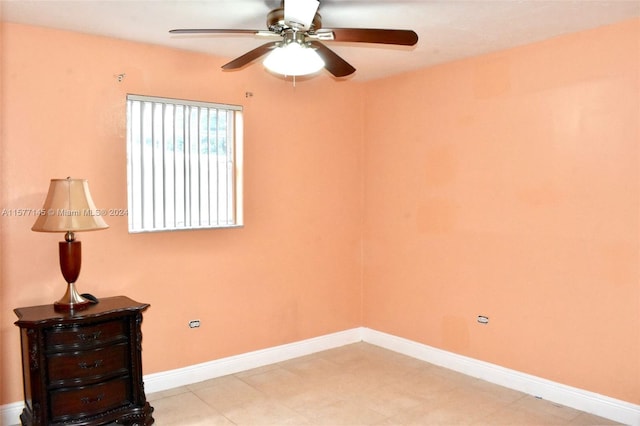 empty room with ceiling fan and light tile flooring