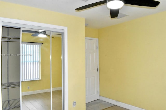 unfurnished bedroom with ceiling fan, a closet, and hardwood / wood-style floors