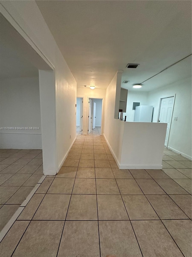 hall featuring light tile patterned floors