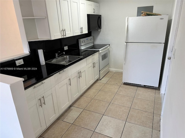 kitchen with light tile patterned floors, white cabinetry, white appliances, and sink