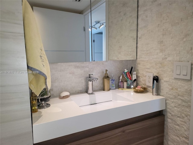 bathroom with tasteful backsplash and vanity