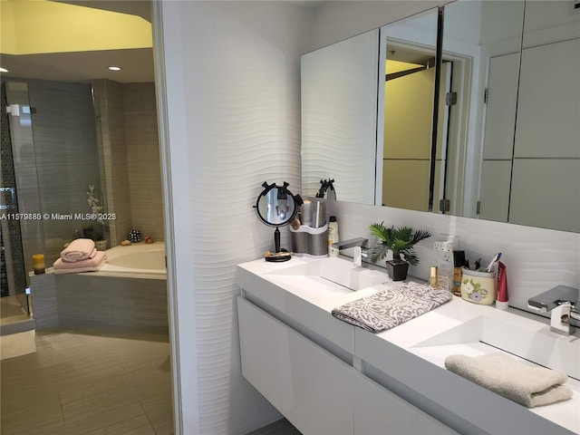 bathroom with vanity and a relaxing tiled tub