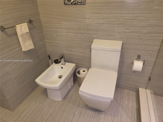 bathroom featuring toilet and a bidet