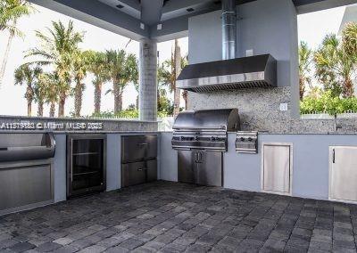 view of patio with an outdoor kitchen, beverage cooler, and a grill