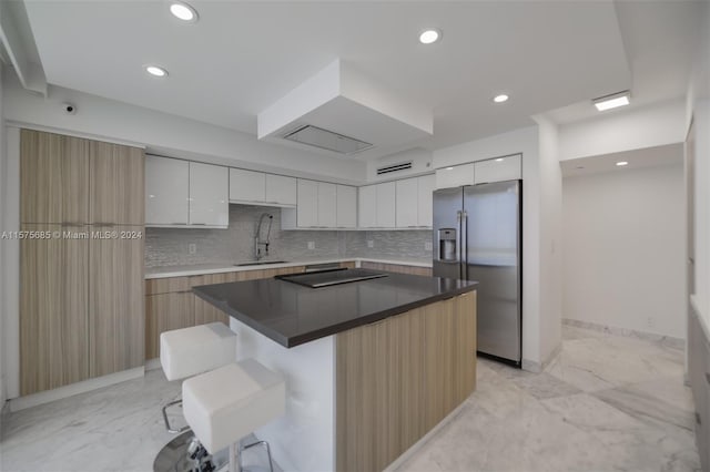 kitchen featuring stainless steel fridge with ice dispenser, a center island, white cabinets, sink, and tasteful backsplash