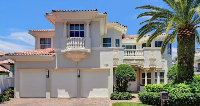 mediterranean / spanish-style house featuring a garage and a balcony