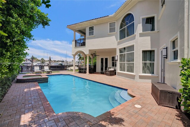 view of swimming pool featuring a patio and an in ground hot tub