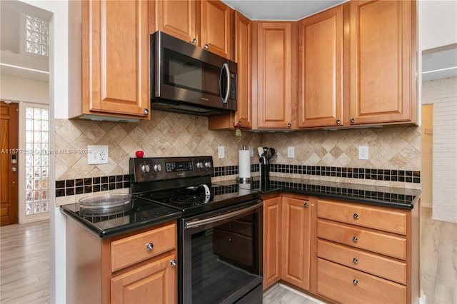 kitchen with light hardwood / wood-style flooring, tasteful backsplash, and range with electric stovetop