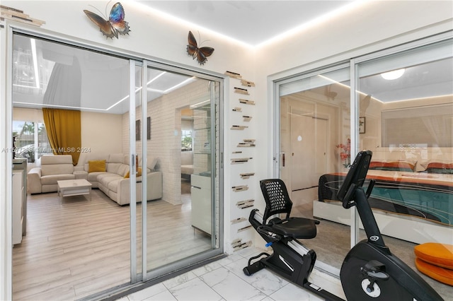 exercise room featuring a wealth of natural light and light tile floors