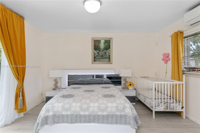 bedroom featuring an AC wall unit and hardwood / wood-style floors