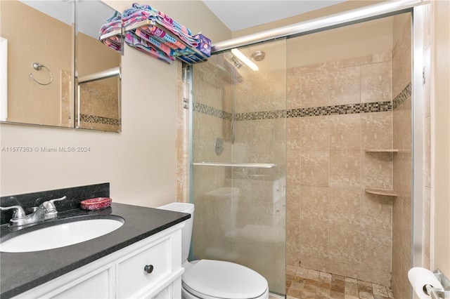 bathroom with an enclosed shower, vanity, and toilet