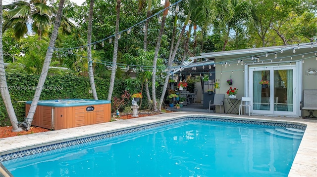 view of swimming pool with a hot tub and a patio