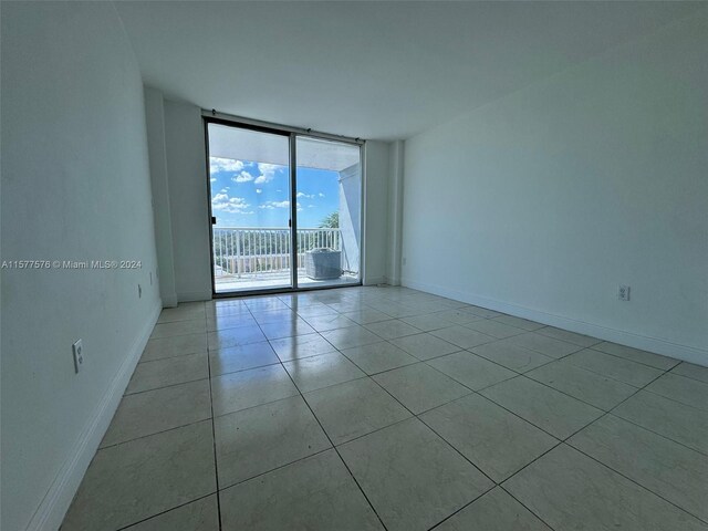 tiled empty room with floor to ceiling windows