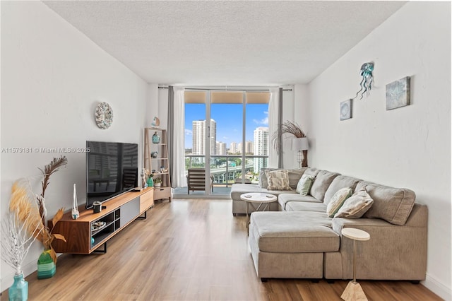 living room featuring a textured ceiling, hardwood / wood-style flooring, and expansive windows