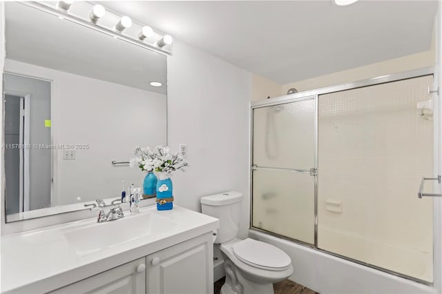 full bathroom featuring bath / shower combo with glass door, toilet, and vanity