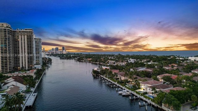 aerial view at dusk featuring a water view