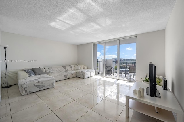 living room featuring floor to ceiling windows, a textured ceiling, and light tile floors