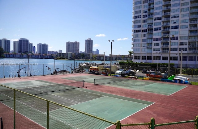 view of tennis court with a water view