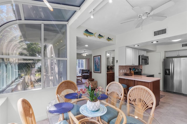 tiled dining area featuring lofted ceiling and ceiling fan