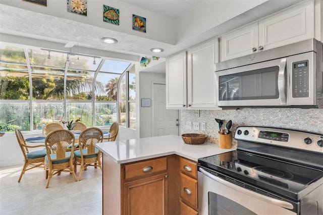 kitchen with backsplash, a healthy amount of sunlight, and appliances with stainless steel finishes