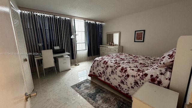 tiled bedroom featuring a textured ceiling