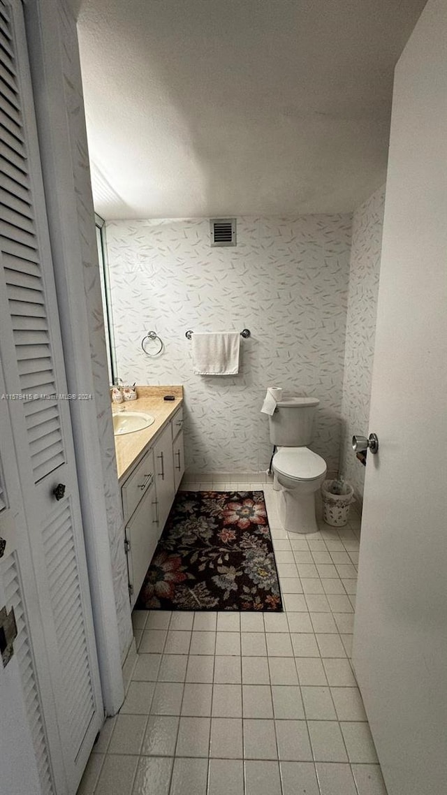 bathroom featuring vanity, toilet, and tile floors