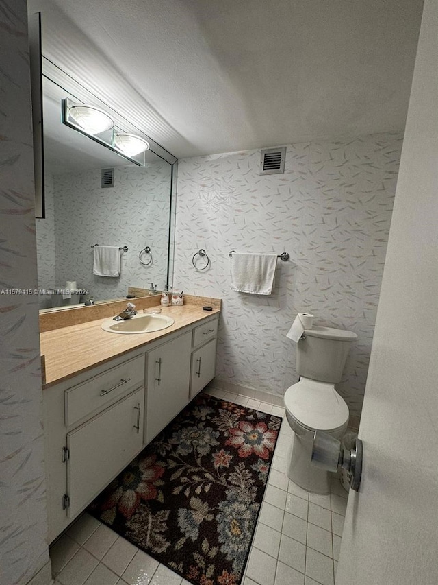 bathroom featuring tile floors, toilet, and vanity