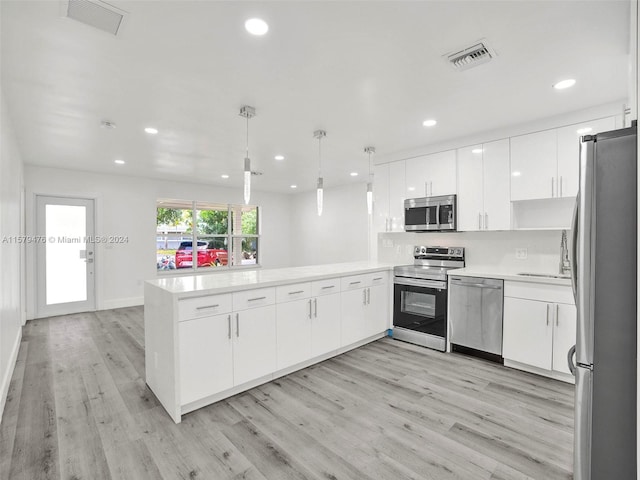 kitchen featuring kitchen peninsula, appliances with stainless steel finishes, and light wood-type flooring