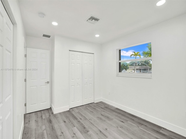 unfurnished bedroom with a closet and light hardwood / wood-style flooring