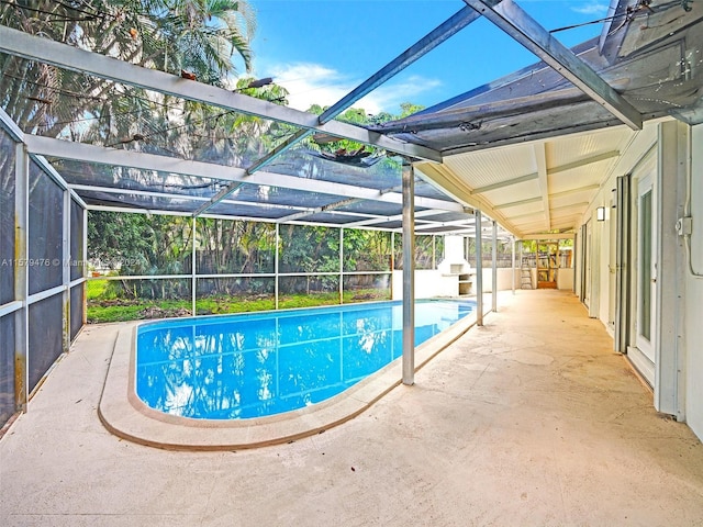 view of swimming pool with a patio area and a lanai