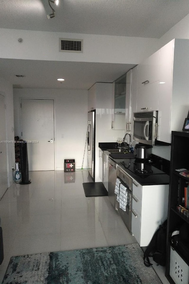 kitchen with sink, appliances with stainless steel finishes, and white cabinetry